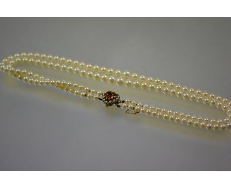 A twin-strand graduated cultured pearl necklace, set on a heart-shaped clasp centred by a conforming citrine within a border 