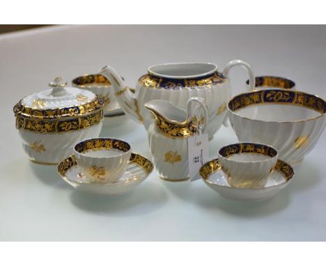 An English porcelain partial tea service, c. 1800, possibly Caughley, each piece of wrythen form, decorated with gilt sprigs 