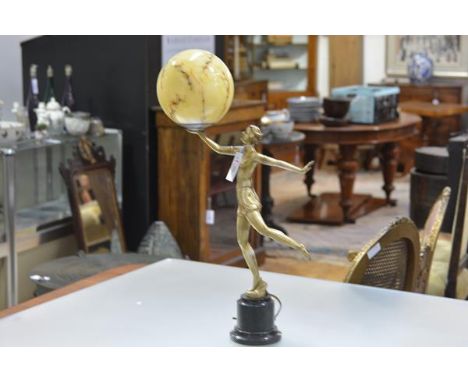 A gilt-metal figural table lamp, c. 1930, modelled as a dancing girl, her right arm upraised and supporting a marbled glass s