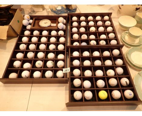 Unusual collection of golf balls in three display cases with a mantel clock 