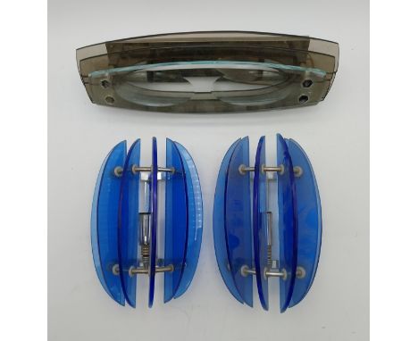 Two mid-century blue glass and tubular metal wall sconces/lights, along with another layered smoked glass wall mounted light 