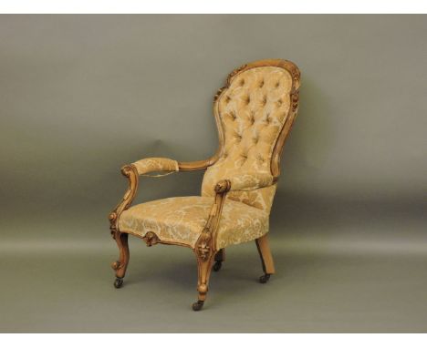 A Victorian walnut moulded frame spoon and button back armchair,  reupholstered with gold floral patterned fabric, Provenance