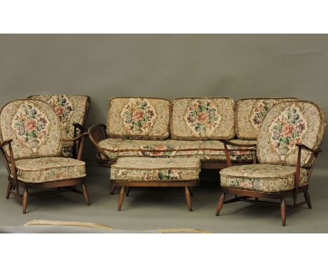 An Ercol settee, with foot stool, two matching armchairs, and another
