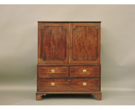 A Georgian mahogany dwarf linen press, a moulded edge top over two doors, the base consisting of two short and one long drawe