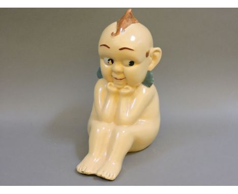 A Kewpie advertising stoneware figure, circa 1950, with polychrome glazed face and hair, stamped to the bottom
