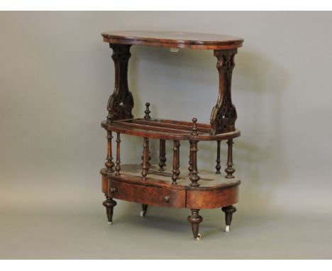 A Victorian rosewood two division canterbury, with shaped and foliate pierced panels on turned rails, a drawer in the base wi