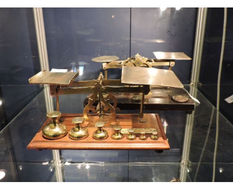 A Samuel Senior brass and oak postal scale, with a set of brass bell weights, and a set of Waterlow & Sons postal scales