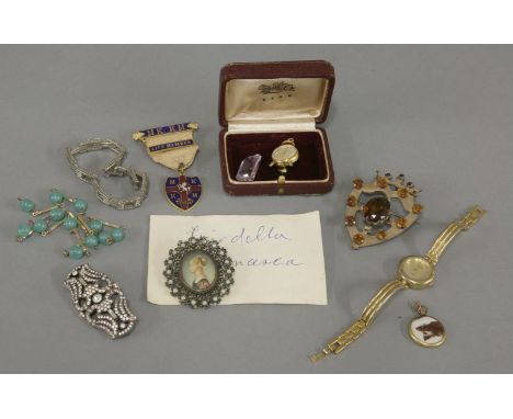 A Scottish rolled gold paste set shield brooch, a paste set Art Deco plaque brooch, a gold plated Jean Perret alarm clock sty