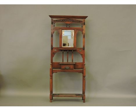 A Victorian walnut hall stand, with a bevelled mirror panel back, glove drawer, on turned front legs united by a shelf, Prove