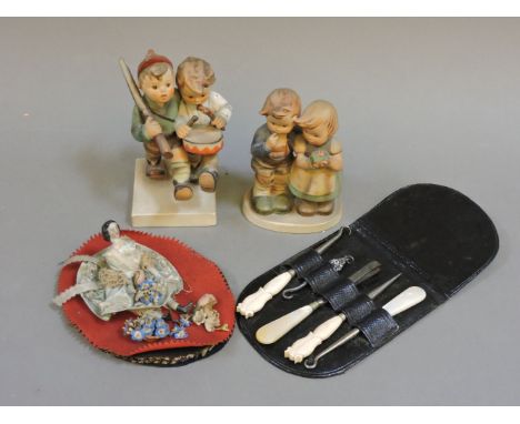Two Goebel figures of children, a small doll on fabric, and a button hook set
