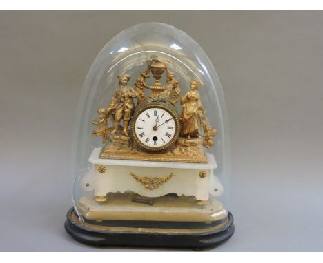 A gilt metal mantel clock, surmounted with figures, on an alabaster base with a dome stand, 43.5cm