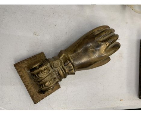 A VINTAGE BRASS DOOR KNOCKER IN THE SHAPE OF A HAND 