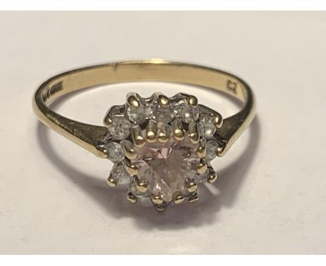 A 9 CARAT GOLD RING WITH HEART SHAPED PINK STONE SURROUNDED BY CUBIC ZIRCONIAS SIZE K/L 