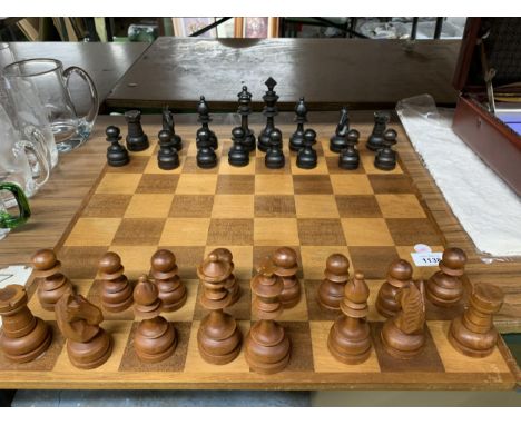 A LARGE WOODEN CHESSBOARD WITH A FULL SET OF WOODEN CHESS PIECES 