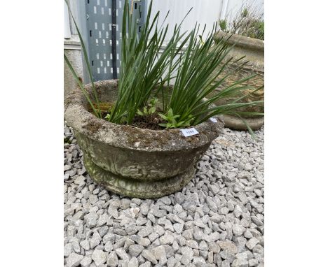 A ROUND RECONSTITUTED STONE PLANTER 