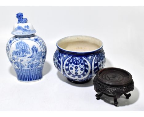 A modern Chinese blue and white ceramic jar and cover, the finial modelled with a Dog of Fo, decorated with a landscape scene