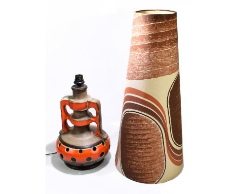 A mid century West German floor lamp, with pierced decoration in colours of red/orange on a black ground, with comical shade,