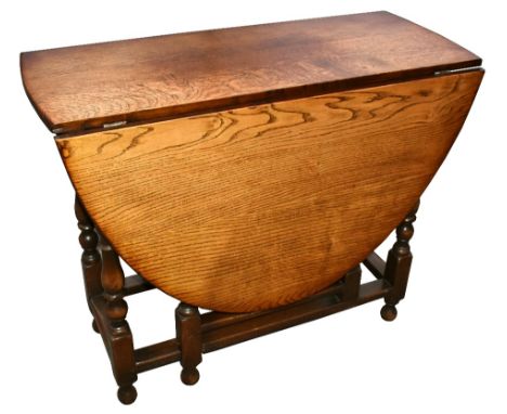 A reproduction oak-drop leaf gateleg dining table, raised on bun feet, width 91cm, height 74cm, with four rush seated ladder 