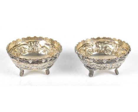A pair Indian white metal circular dishes, decorated throughout with scrolling foliage, each stamped 'silver' to the undersid