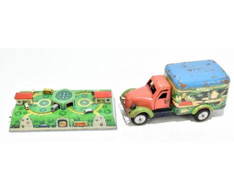 A tin plate clockwork truck, decorated with a pixie and a girl with frogs on a pond, in a cardboard box, with a tin plate clo