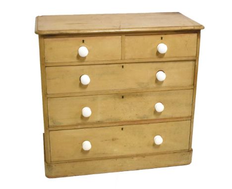 An old pine chest of two short over three long drawers, with white ceramic handles, raised on plinth base, width 103cm, depth