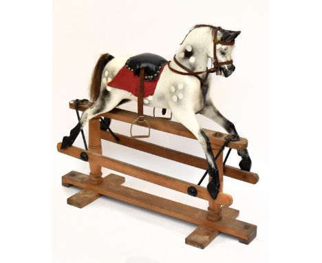 A vintage dappled grey rocking horse raised on a trestle base, length approx 115cm.