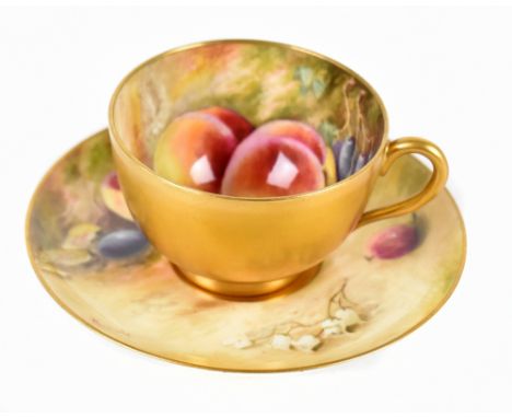 WILLIAM RICKETTS FOR ROYAL WORCESTER; a hand painted teacup and saucer painted with fruit, signed to the rim, puce factory ma
