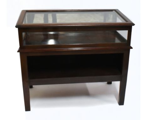 An Edwardian mahogany display vitrine, the upper glazed section with hinged angled lid above a base with shelf and raised on 