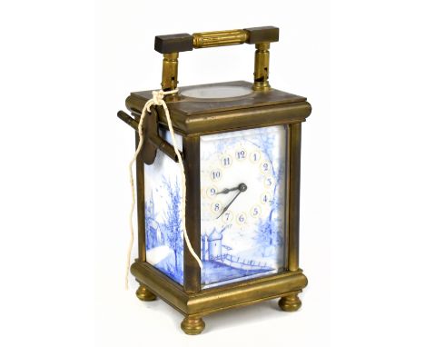A late 19th/early 20th century brass eight day carriage clock with blue and white enamelled face and side panels depicting a 