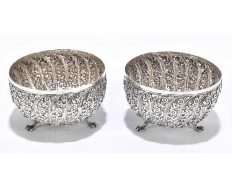 A pair of Eastern white metal bowls with floral embossed wrythen decoration and raised on three paw feet, unmarked, diameter 