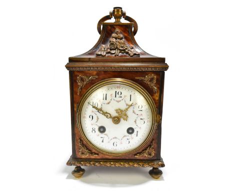 A circa 1900 French tortoiseshell gilt metal mounted boudoir clock with swing loop handle above circular enamel dial set with