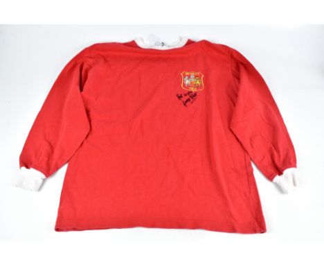 GEORGE BEST; a Manchester United 1963 retro reproduction shirt, signed to the front, size L.
Additional InformationCreasing a