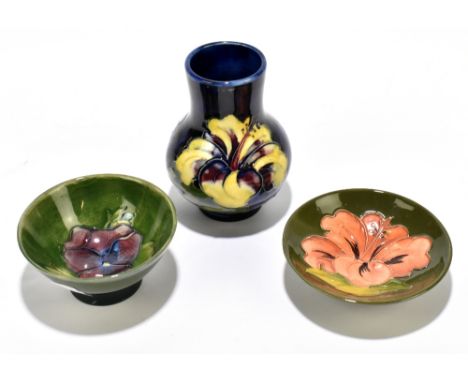 MOORCROFT; three small pieces including a dark blue ground floral decorated vase, height 10.25cm, a green dish decorated in t