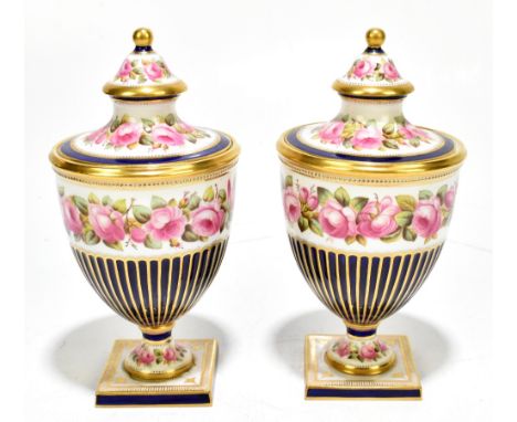 COPELANDS; a pair of porcelain rose painted urns and covers each with gilt heightening on a cobalt blue ground, painted marks
