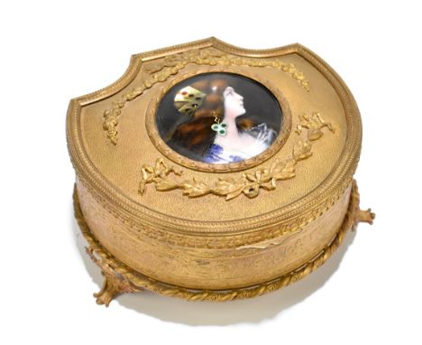 LIMOGES; a shaped gilt metal trinket box, the hinged lid centred with a circular jewelled enamel plaque painted with the head