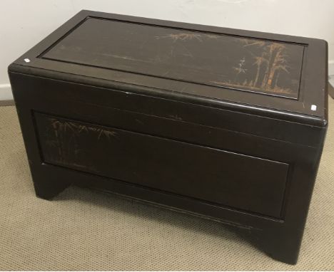 An Eastern carved camphor wood trunk decorated with fielded panels of bamboo, raised on bracket feet, 101 cm wide x 52 cm dee