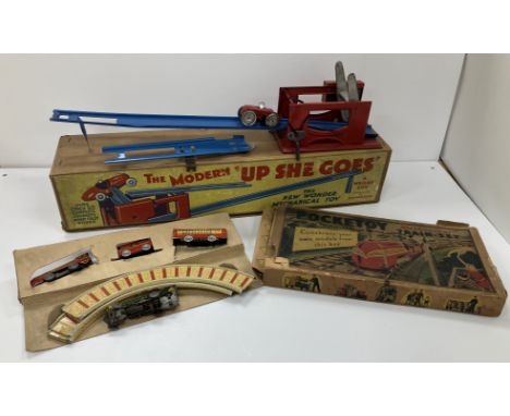 A boxed "Pocketoy" mechanical train set with cut out model station, bridge, etc and a boxed "The Modern Up She Goes", the "Ne