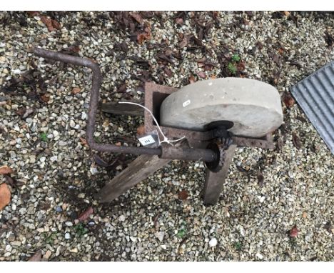 A stone knife sharpener on wooden stand, 73 cm high, together with a wooden ladder (for decorative purposes only)