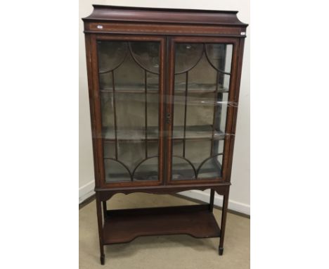 An Edwardian mahogany display cabinet, the caddy top over two astragal glazed doors enclosing three lined shelves, on square 