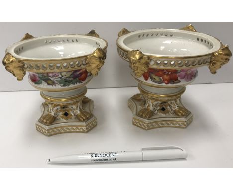 A pair of Crown Derby pot pourri vases, set with floral bands and gilt decorated masks, raised on lion's paw feet to stepped 