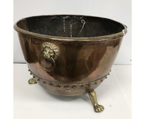 A Victorian copper copper, adapted with lion mask ring handles and lion's paw feet as a log container, 59 cm diameter x 41 cm