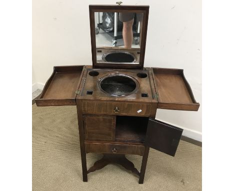 A George III mahogany washstand, the double rising top opening to reveal various bowl and bottle recesses, together with an a