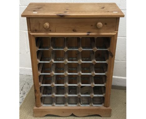 A modern stained pine wine rack, the plain top above a single drawer and 24 bottle galvanised and pine bottle holders, on a b