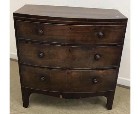 An early 19th Century mahogany and satinwood strung bow fronted chest of three long graduated drawers with turned knob handle