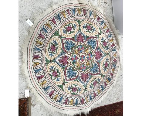 A vintage wool and crewel work type rug of circular form with floral design on a cream ground, approx 145 cm diameter