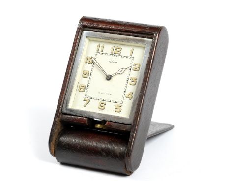 A 1930'S LE COULTRE EIGHT DAY TRAVELLING CLOCK, the rectangular dial with Arabic numerals and luminous hands in a folding dar