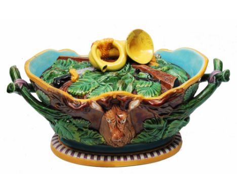 A 19TH CENTURY MAJOLICA GAME DISH AND COVER, the sides moulded in relief with two stags' heads and foliage, the lid with bugl