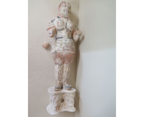 A painted pottery figure of a guard Tang dynasty standing on a rockwork base, dressed in full armour, armour plates secured b