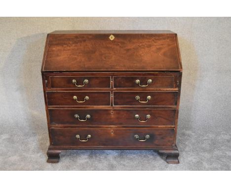A Georgian mahogany bureau with fall front revealing fitted interior above four long drawers on bracket feet. H.107 X 107cm 