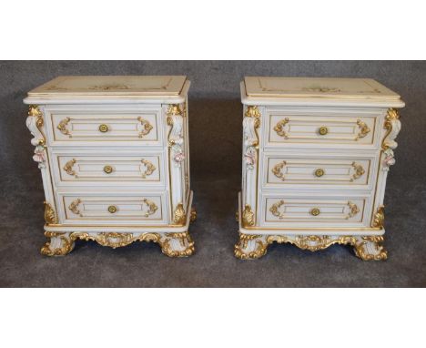 A pair of cream and gilt Rococo style bedside chests fitted three drawers on scrolling bracket feet. 55cm x
36cm. 